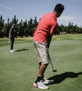 A person putting a ball to a golf hole on a golf course